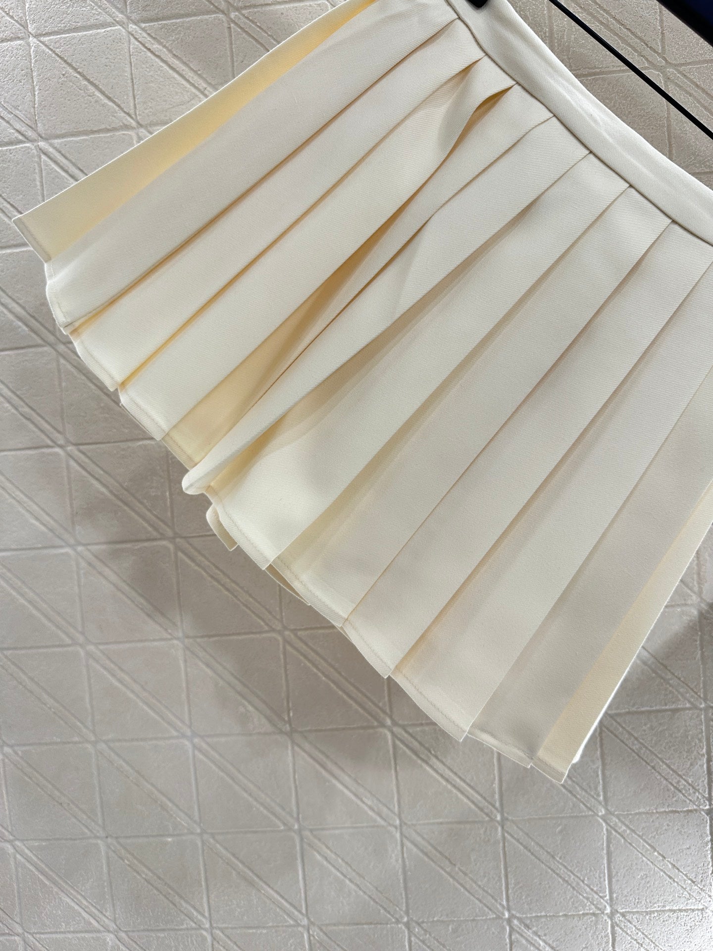 25 High-waisted pleated skirt with one side buckle